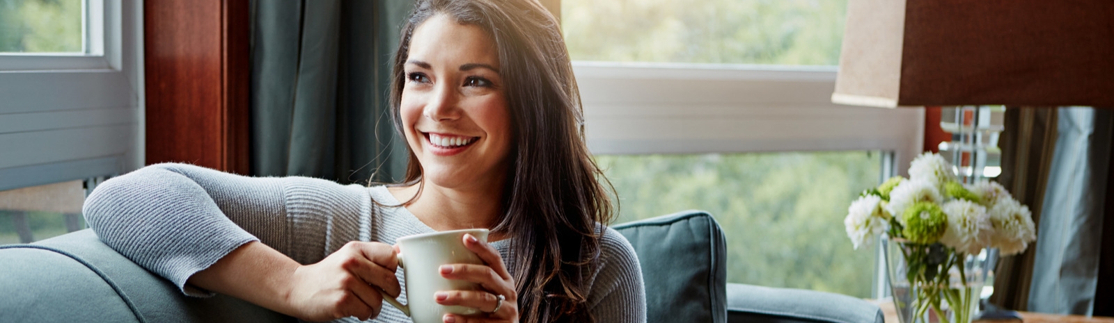 Woman smiling and drinking coffee