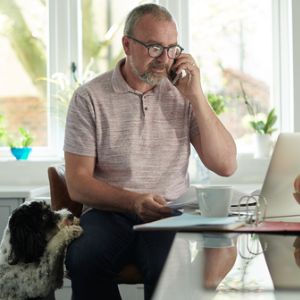 Man in home office talking on cell phone