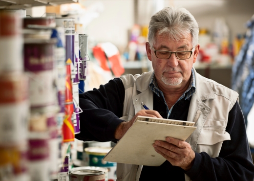 Man working in store and writing on notepad