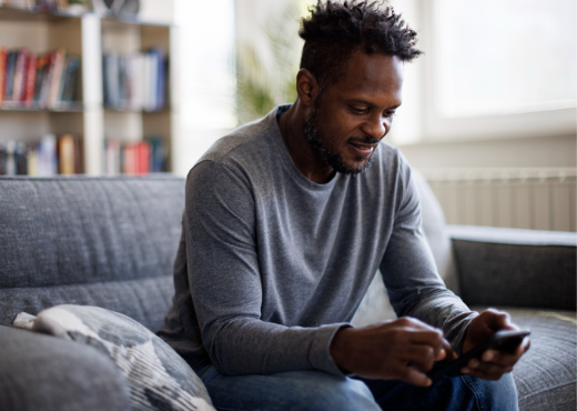 Man holding smart phone sitting on couch