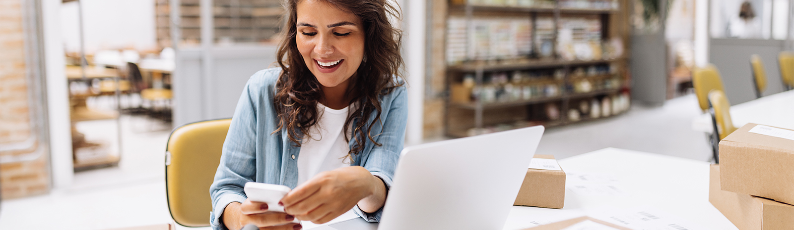 Woman looking at mobile phone in work space