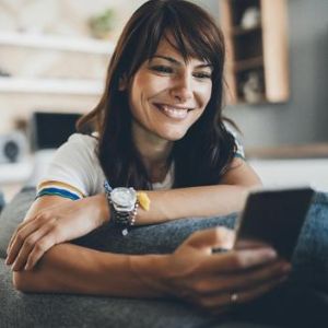 Woman smiling and looking at smart phone