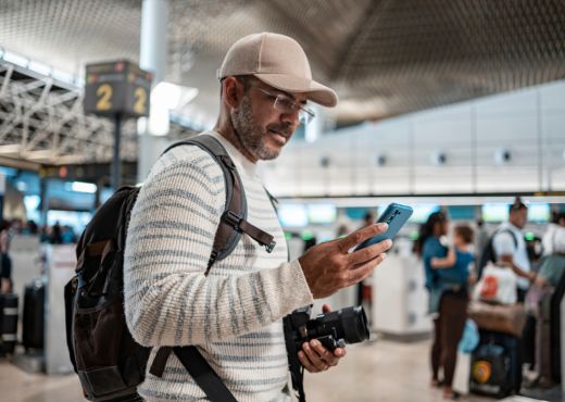 Man at airport looking at smartphone